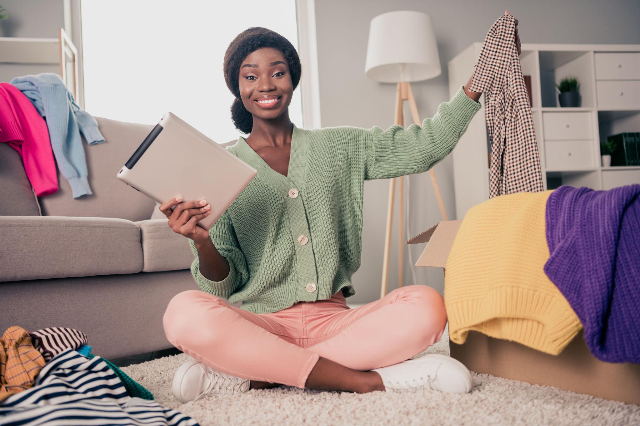 Jeune femme triant ses vêtements avec sa tablette